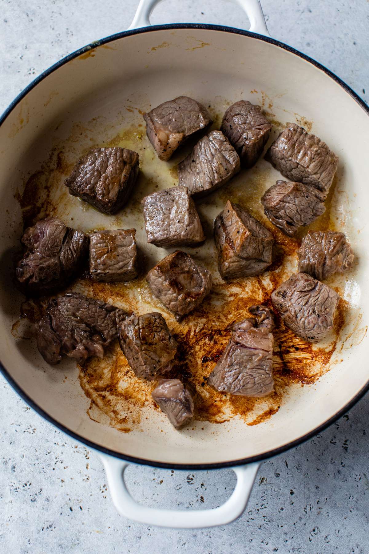 Beef tips browning in a large pot.