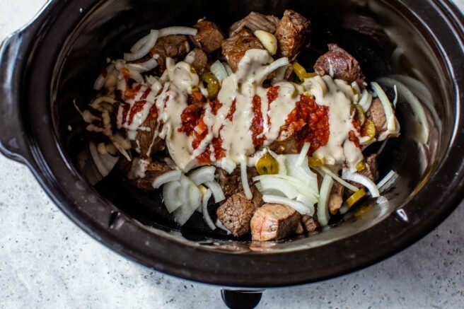 Beef tips covered with salsa, onions, jalapeños and ranch dressing in a crockpot.