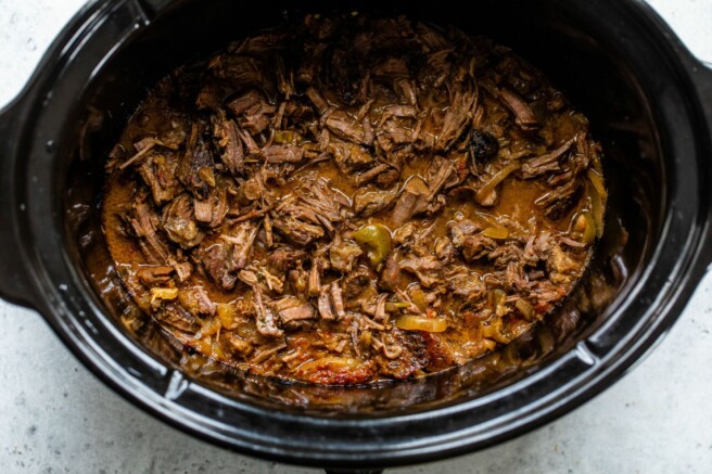 Slow cooker beef tips shredded in a crockpot.