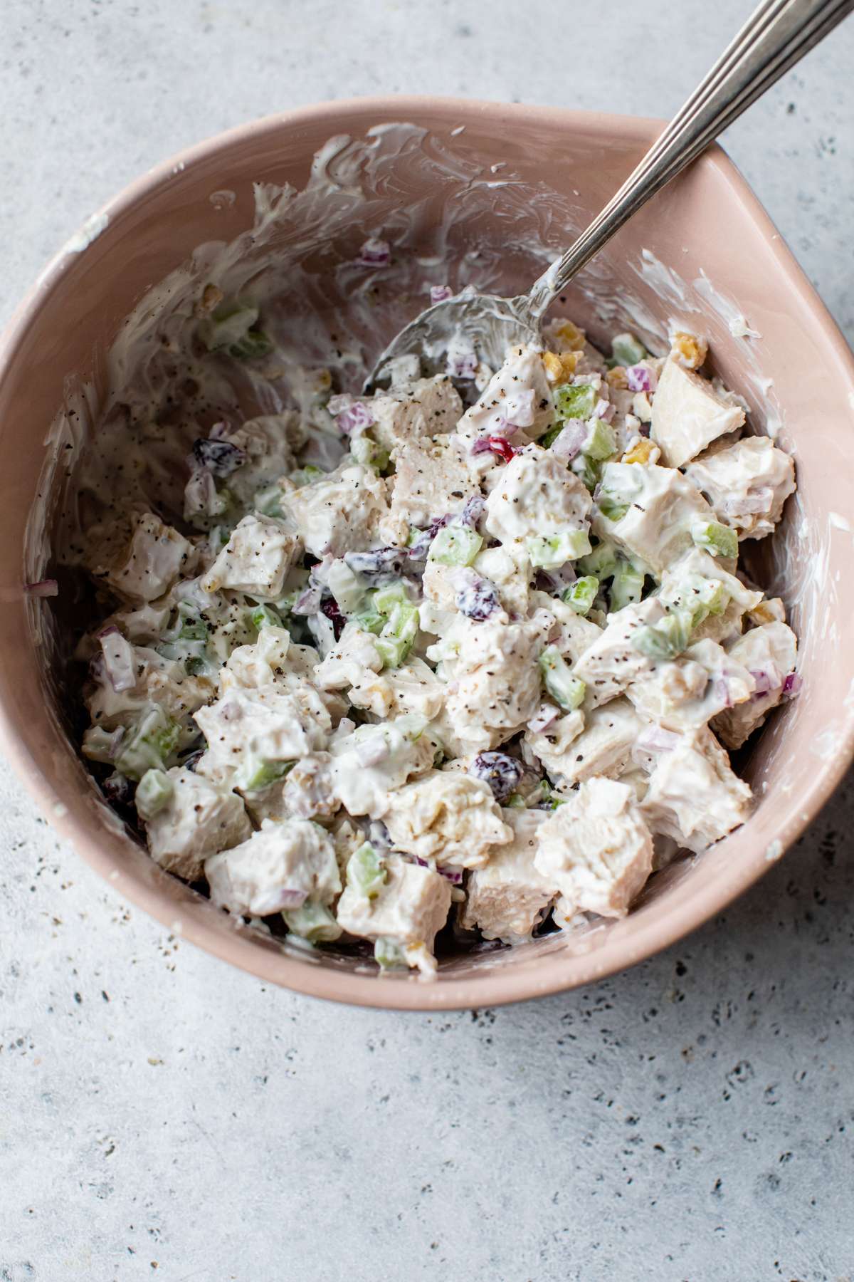 Mixing cranberry-walnut chicken salad in a large bowl.