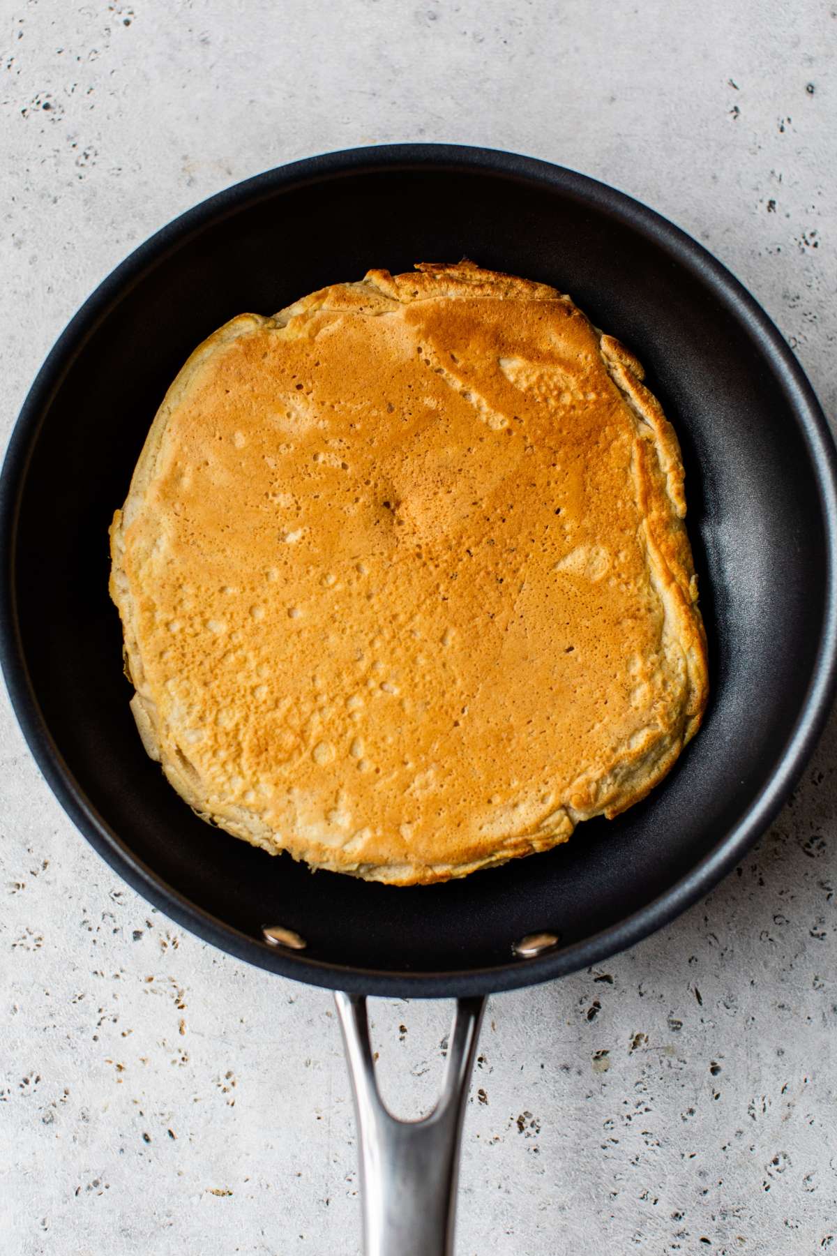 Pancake cooking in a pan.