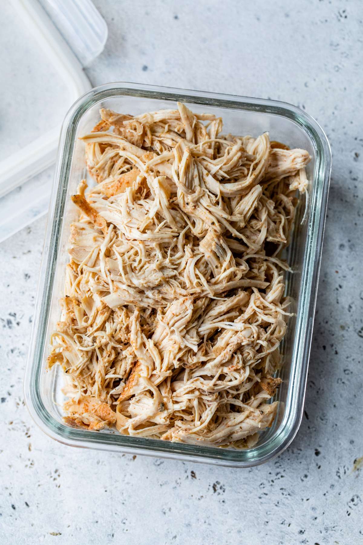 Shredded chicken in a meal prep storage container.