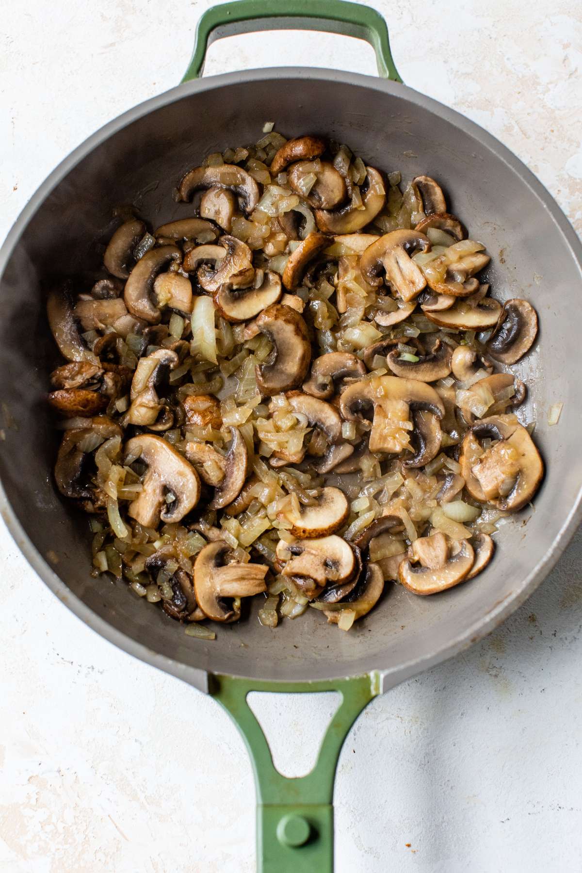 Mushrooms sautéing in a pan.