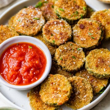Zucchini chips served on a plate with marinara.