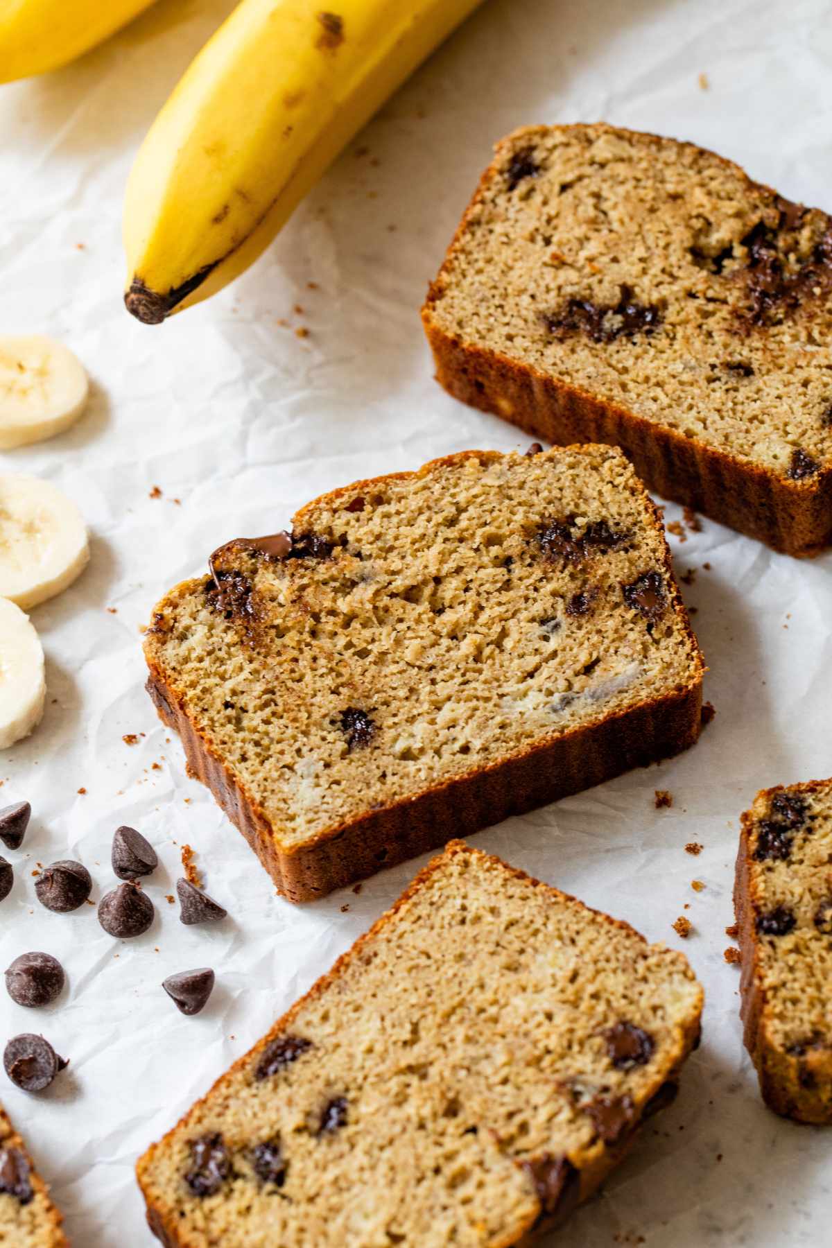 Slices of protein banana bread near bananas.