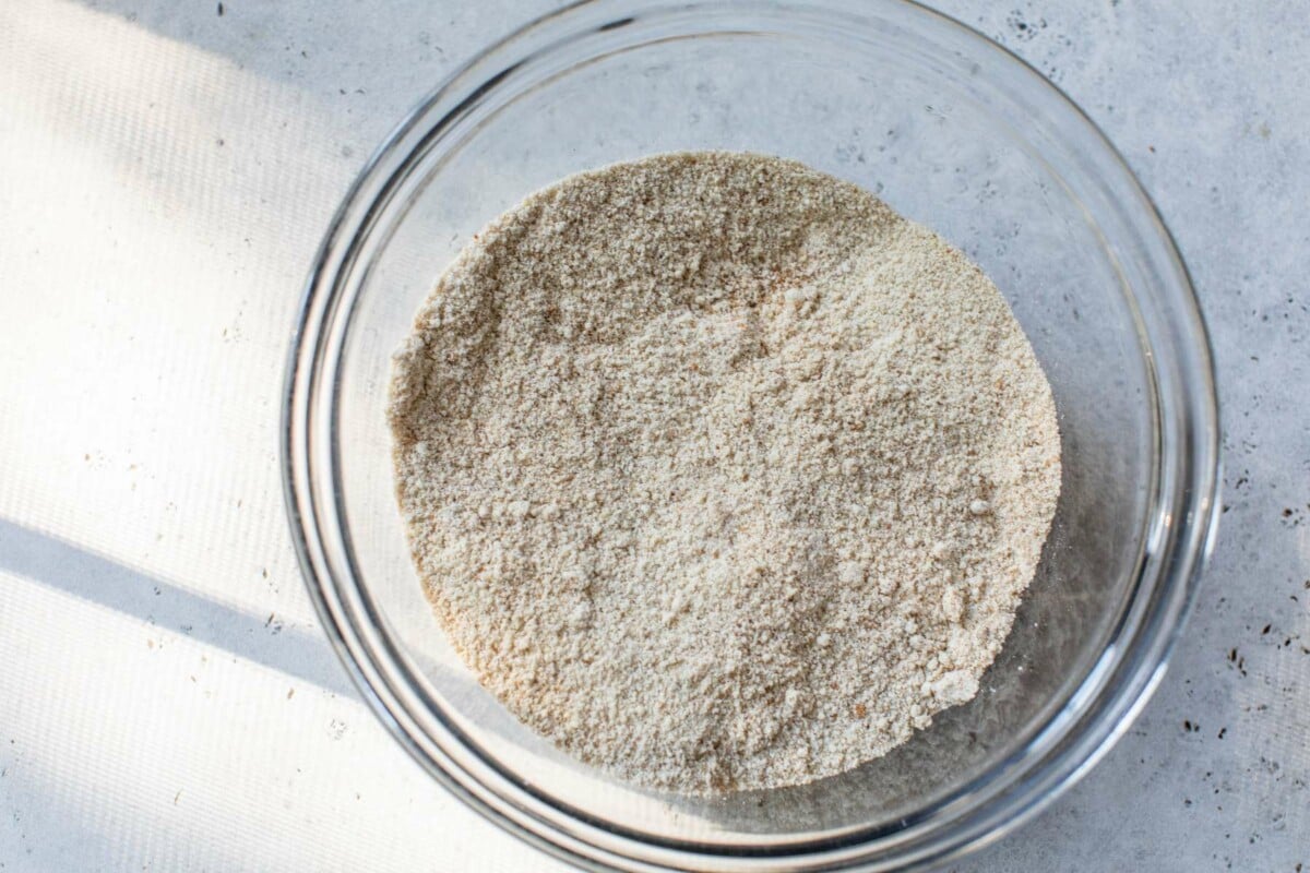 Combining flour with protein powder in a large bowl.